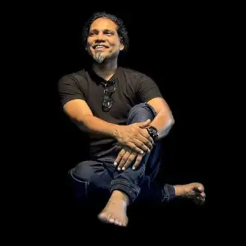 Sajeev Raman Nambiyath seated on stage
